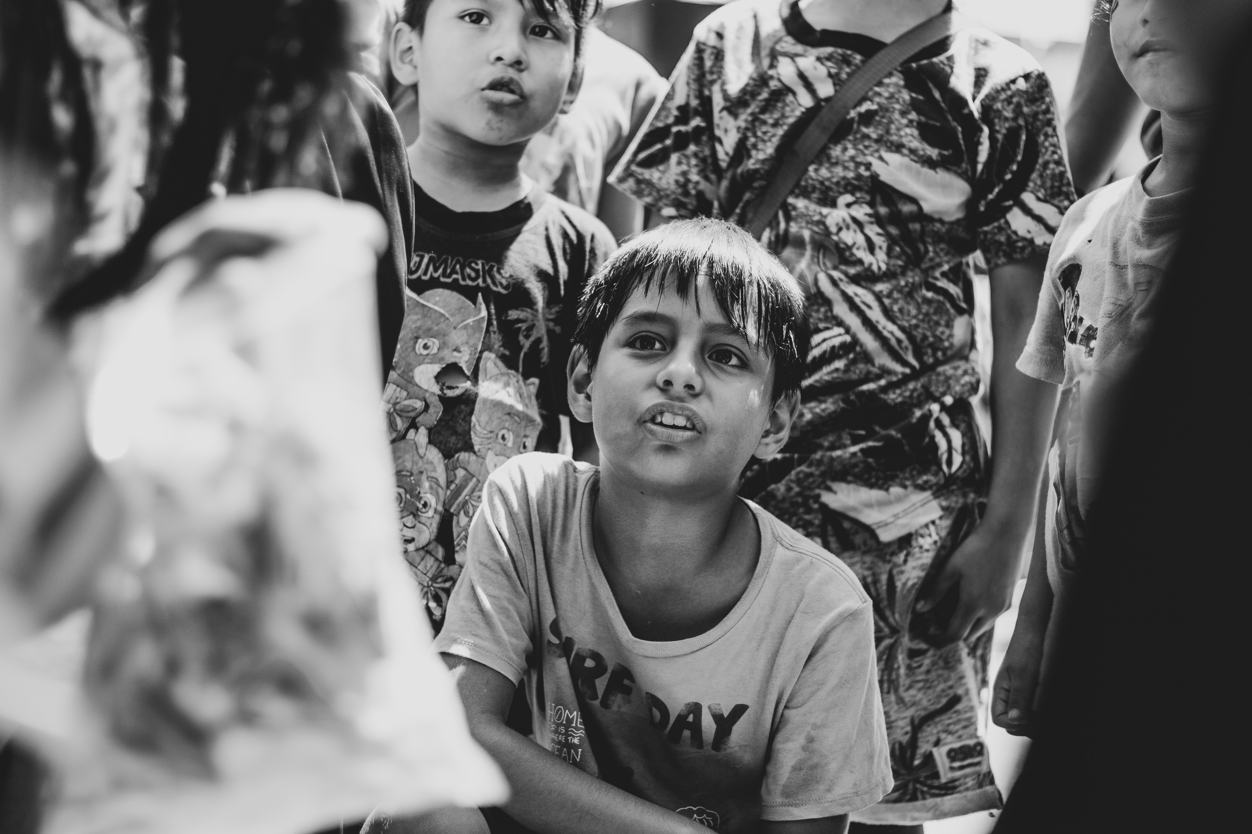 grayscale photo of boy wearing white and black crew-neck t-shirt